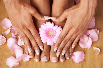 Floral beauty. Cropped view of hands on perfectly pedicured feet with flowers all around.