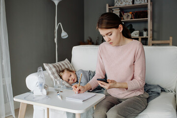 Mother searching treatment on smartphone near sick child