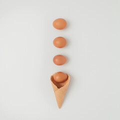 Ice cream cone with egg on white background. Minimal Easter concept. Flat lay. Happy Easter. Creative  minimal Easter holiday concept. Holiday Easter celebration greeting card or idea.