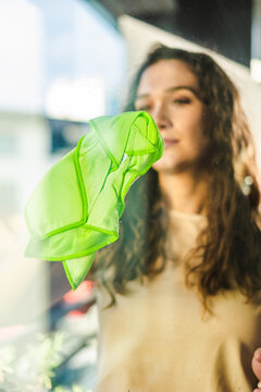 Woman cleaning window on sunny day