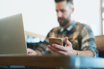 Take your wireless devices wherever you go. Shot of a young man using his cellphone and laptop...