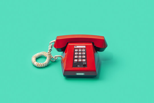 Red vintage telephone over turquoise background