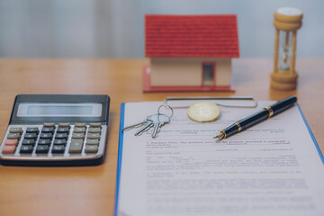 House keys in a lease or home purchase contract with real estate background. Ideas for buying real estate and homes for Cryptocurrency.