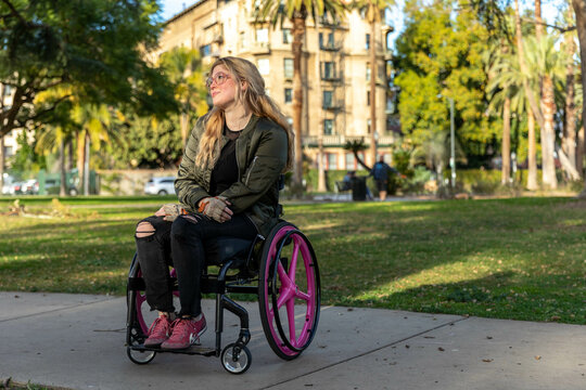 Woman Sits in Wheelchair in a Public Park