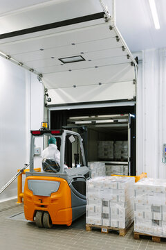 Anonymous man driving an industrial bull in warehouse