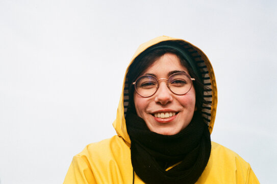 Portrait of a smiley woman wearing a yellow raincoat. Eye contact