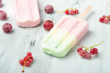 Popsicles on a stick. Bright color, summer mood. Eskimo berry with frozen berries on a light background. Flat-lay