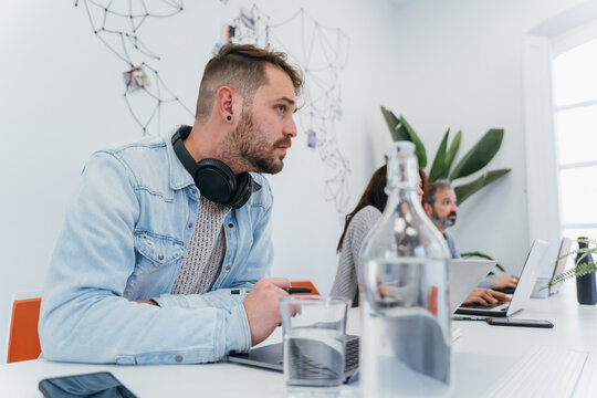 Attentive guy sitting at desk during briefing in office