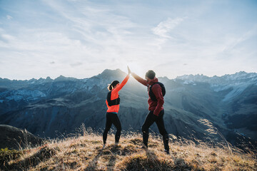 Sports friends giving high five after trail run.