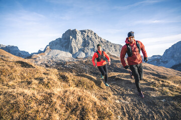 Smiling trail runners in alpine landscape
