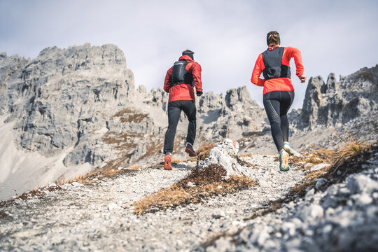 Trail runners running towards stone structures.
