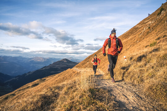 Female runner chasing man through the highlands.