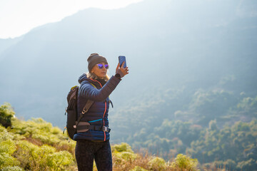 Female hiker taking photos in nature