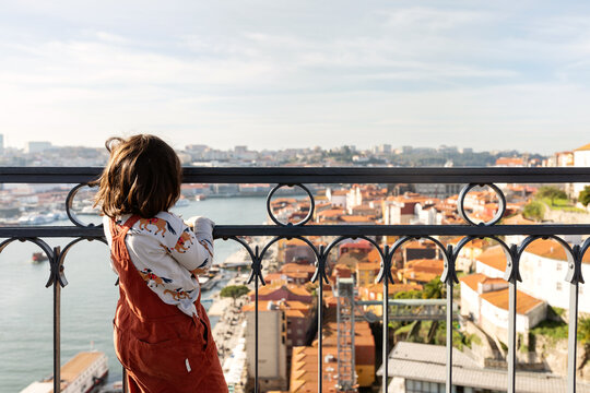 Girl contemplating Porto from balcony