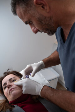 Doctor doing anti baggy eyes injection to patient
