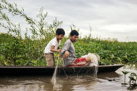 Father and son fishing in the amazon river