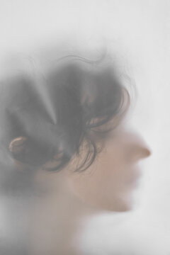 Unrecognizable woman behind translucent cloth