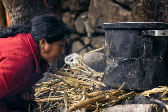 Latin woman lighting a fire to cook