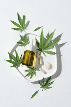 Bottle Of Hemp Cosmetics With Green Leaves Isolated On White