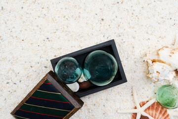 白い砂浜と木の箱に入ったガラス玉と貝殻