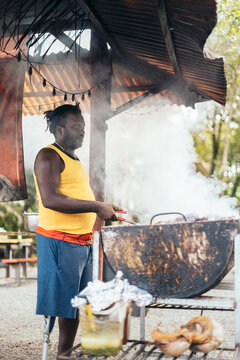 Afro-Caribbean man cooking on a barbeque