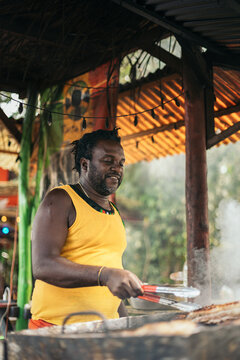 Afro-Caribbean man cooking on a barbeque
