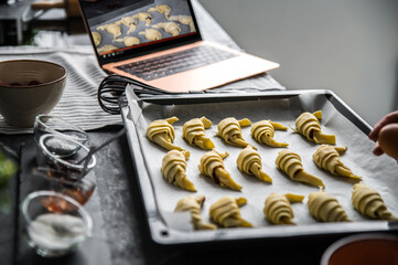 Tray with croissants near laptop