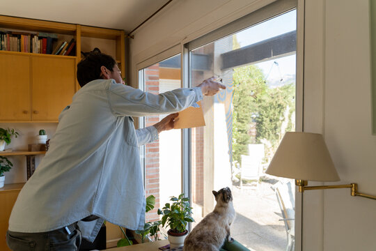 Man trying to catch insect inside the house
