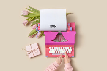 Child typing word mom on vintage typewriter