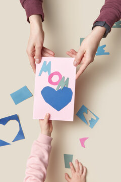 Kid giving mother handmade papercraft card