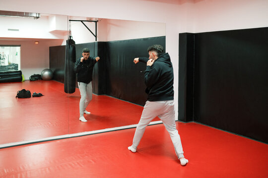 Sportsman shadow boxing in front of mirror