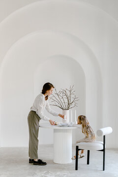Mother with child setting table for Easter holiday