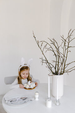 Child sitting at decorated for Easter table 