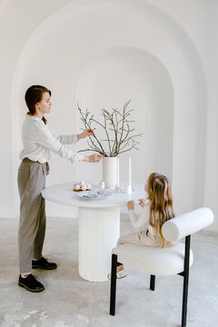 Mother and daughter decorating table for Easter holiday