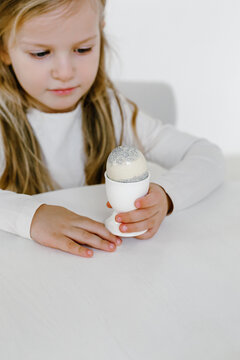 Child with decorated Easter egg in cup