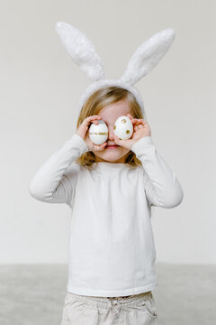 Little kid in bunny ears with Easter eggs 
