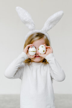 Adorable girl with Easter eggs and in bunny ears