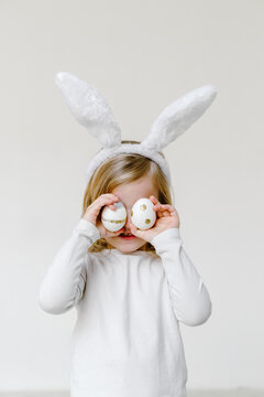 Child covering eyes with Easter eggs 