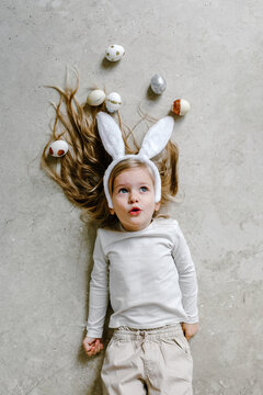 Dreamy child lying on floor with Easter eggs