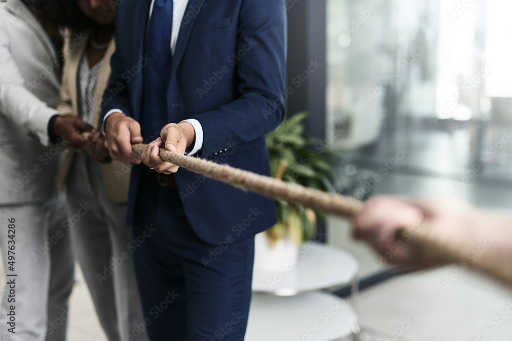 Poster teamwork can defeat any challenge. closeup shot of a group of unrecognizable businesspeople pulling 