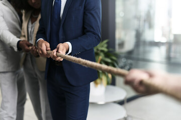 Teamwork can defeat any challenge. Closeup shot of a group of unrecognizable businesspeople pulling together on a rope in an office. - obrazy, fototapety, plakaty