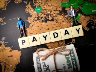 Banknotes,miniature people and toys word with text PAYDAY on a world map background