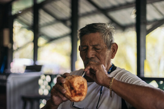 Senior local man drinking coconut