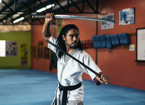 Man training martial arts with katana