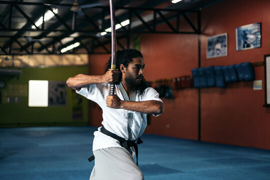 Man training martial arts with katana