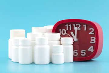 Pile of pill bottles and an alarm clock