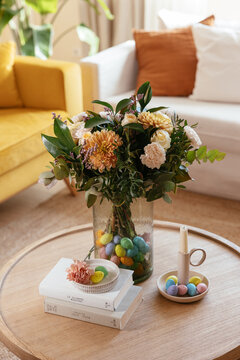 Flower bouquet in vase with eggs on table