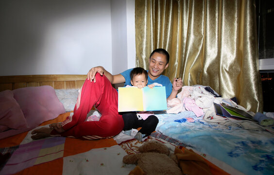Asian father and daughter reading and playing