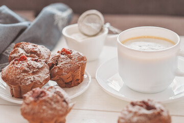 homemade chocolate muffins with berry filling and a cup of coffee on wooden table. home baking, tasty breakfast for weekend.