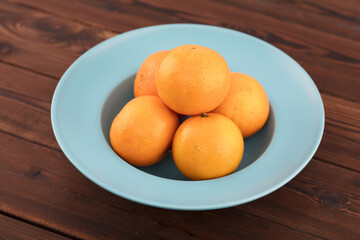 Several oranges in straw hat dish